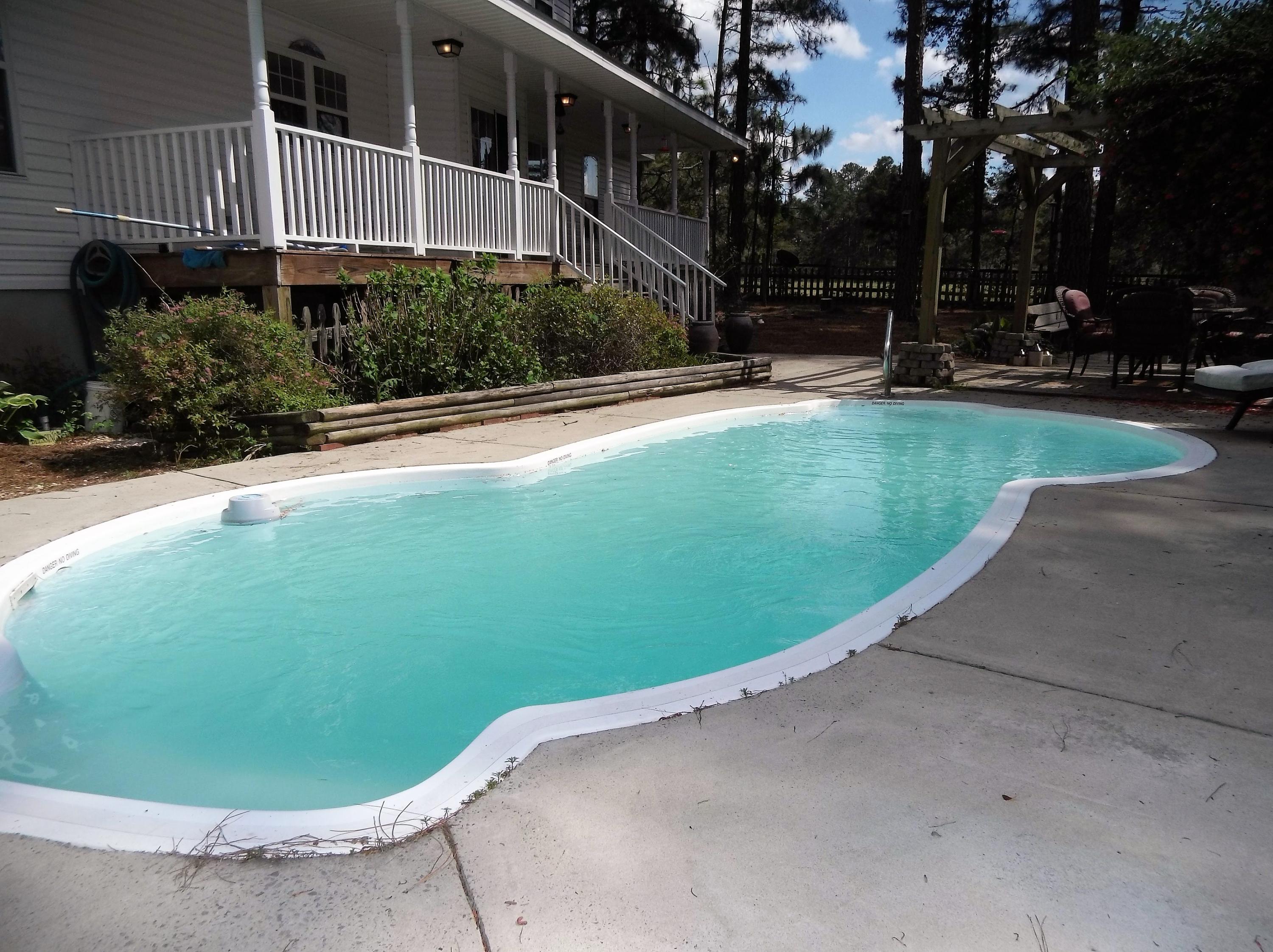 229 B Foxfire Road Aberdeen, NC 28315 - Photo 43 of 47 Just steps from the porch, in ground pool with landscaped pool deck will be your backyard vacation spot.