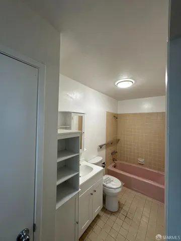 a bathroom with a toilet a sink and mirror