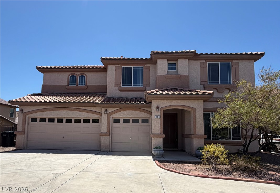 728 Blue Crystal Creek Road Henderson, NV 89002 - Photo 1 of 2 A welcoming front entrance features an arched portico and a well-maintained driveway leading to two spacious garages.