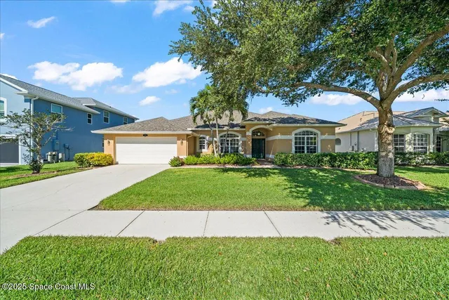 a front view of a house with a garden and yard