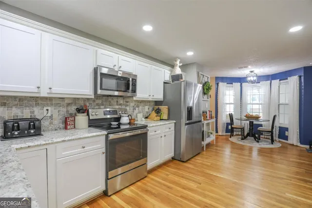 a kitchen with stainless steel appliances granite countertop a refrigerator stove microwave and sink