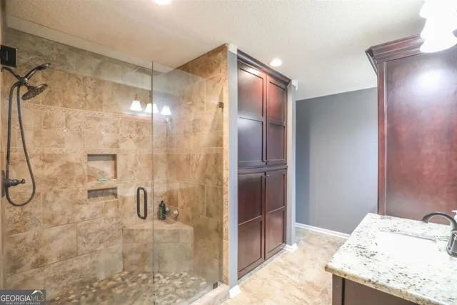 a bathroom with a granite countertop sink and shower