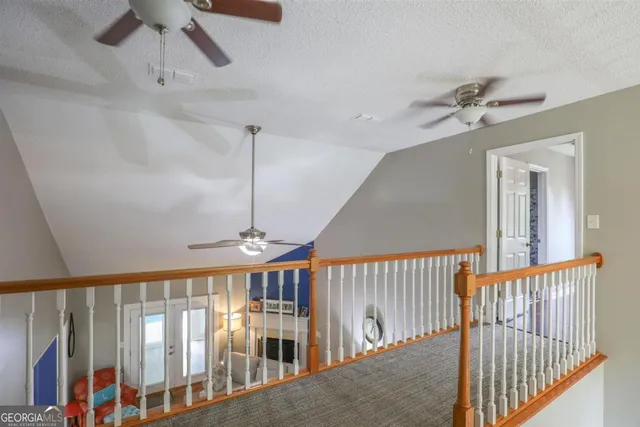 a view of staircase with railing and white walls