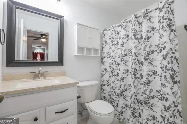 a bathroom with a toilet a sink and a mirror