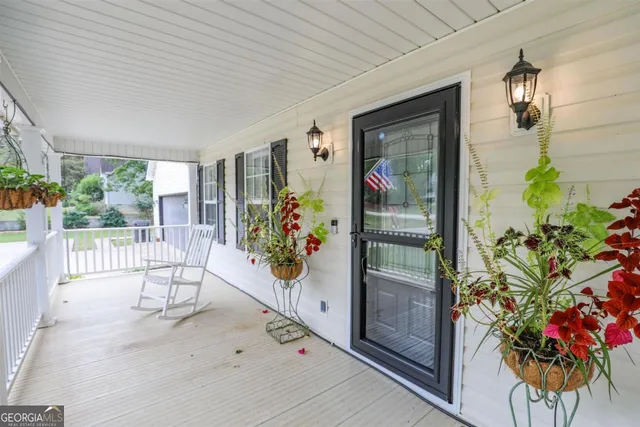 a view of a hallway with wooden floor and a potted plant