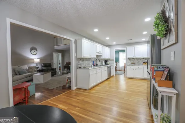 a large kitchen with cabinets a sink and a potted plant