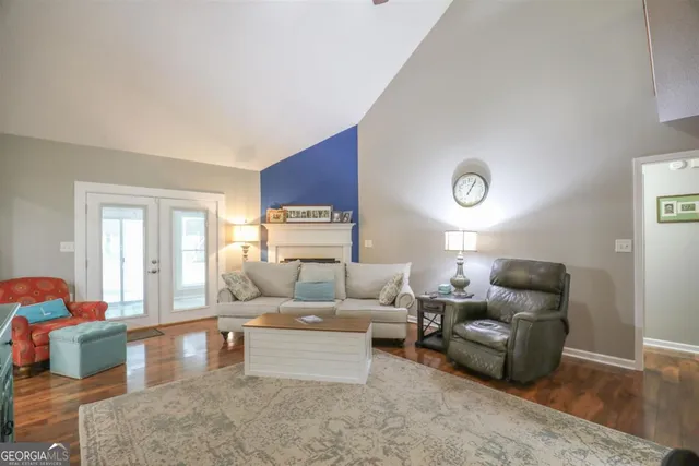 a living room with furniture wooden floor and a large window