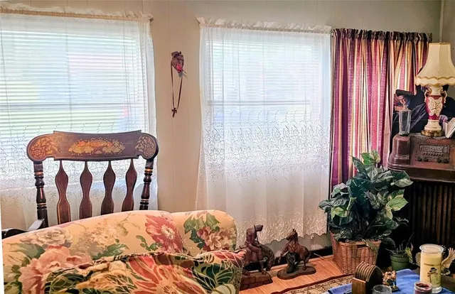 a hallway with painting on the wall and a potted plant