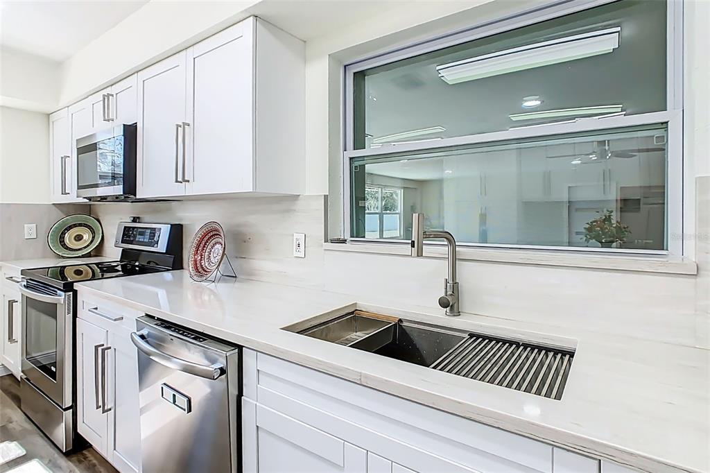 1700 South Miller Road Valrico, FL 33594 - Photo 18 of 53 a kitchen with stainless steel appliances granite countertop a sink and cabinets with wooden floor