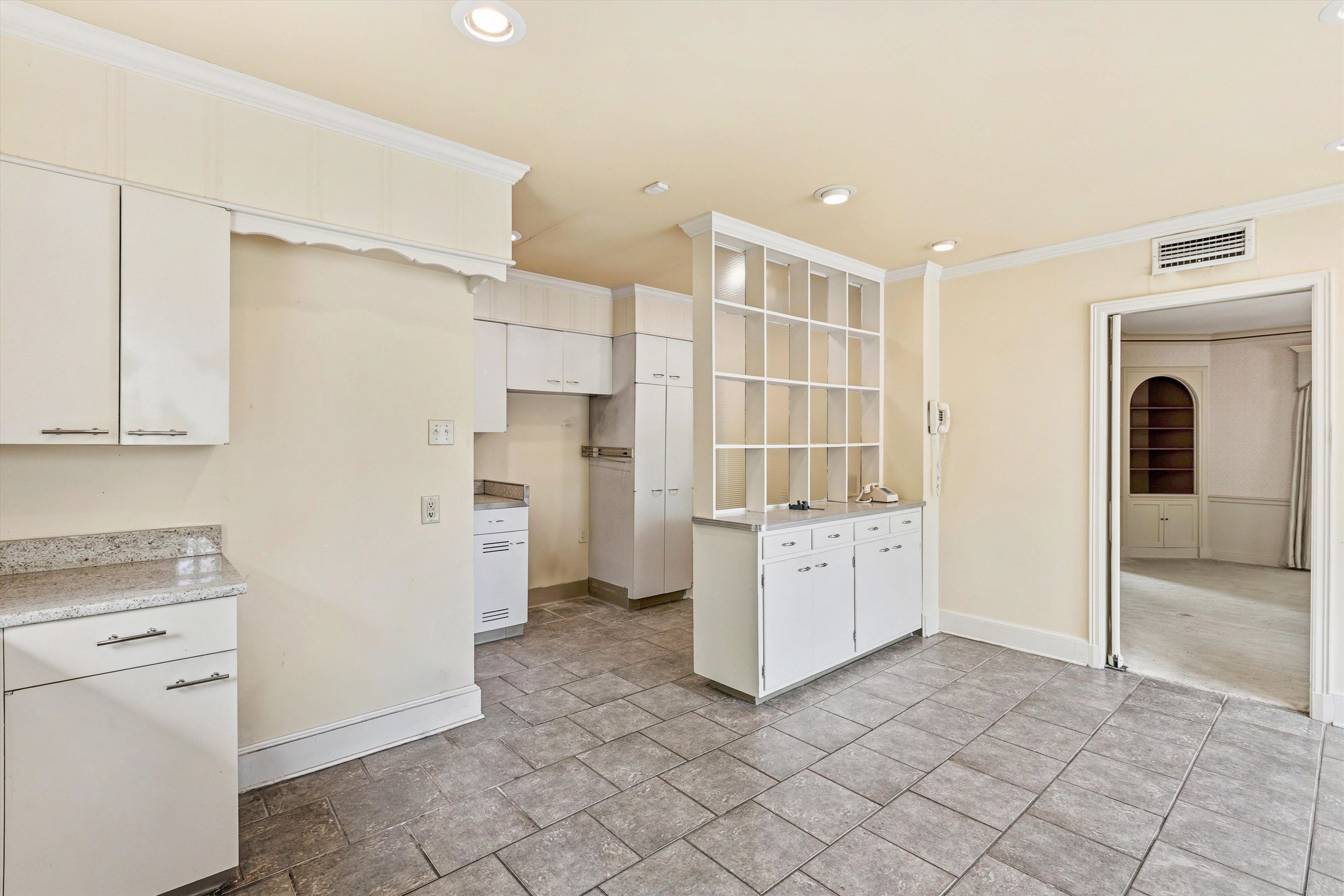 3758 Walnut Grove Road Memphis, TN 38111 - Photo 10 of 34 Light-filled Kitchen & Breakfast Room with abundant cabinetry, solid surface countertops, and tile flooring. Large windows and a charming breakfast area provide great natural light, while built-in storage and serving space add functionality.