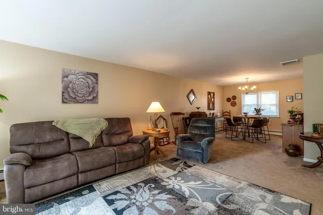 a living room with furniture a couch and potted plant