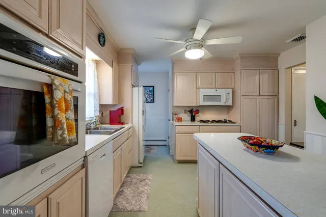 a kitchen with kitchen island granite countertop a sink cabinets and stainless steel appliances