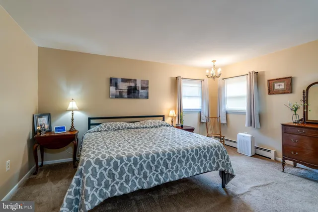 a bedroom with a bed a lamp and a large window