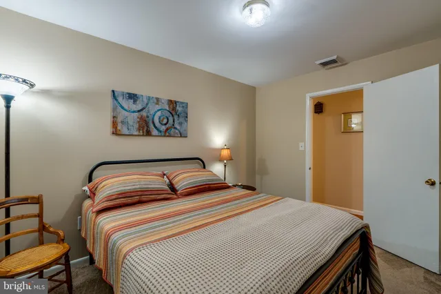 a bedroom with a bed and painting on the wall