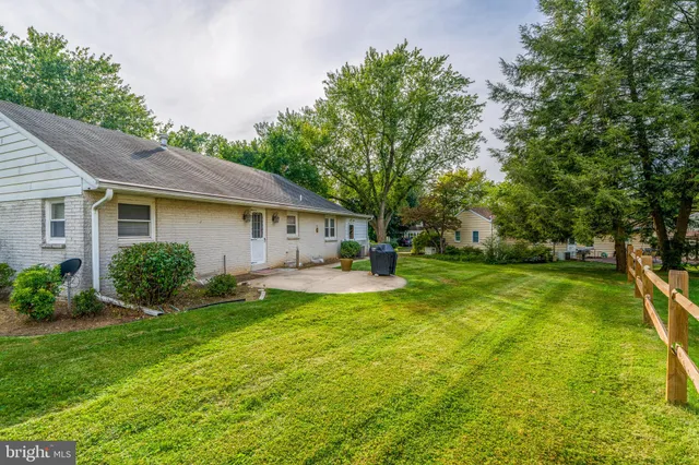 a view of a house with a yard and tree s