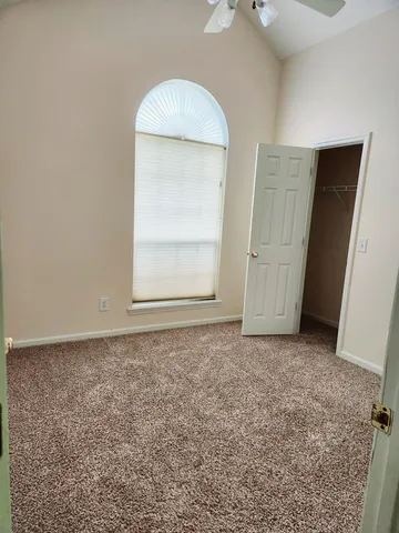 an empty room with cabinet and a mirror