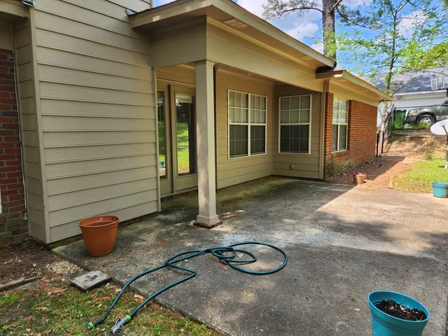 a view of a chair and fire pit in front of house