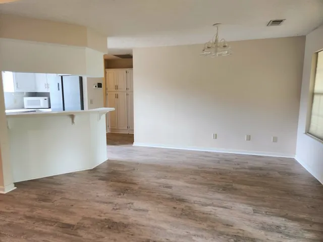 an empty room with a fireplace and wooden floor