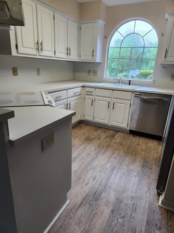 a kitchen with stainless steel appliances granite countertop a sink a stove and a wooden floors