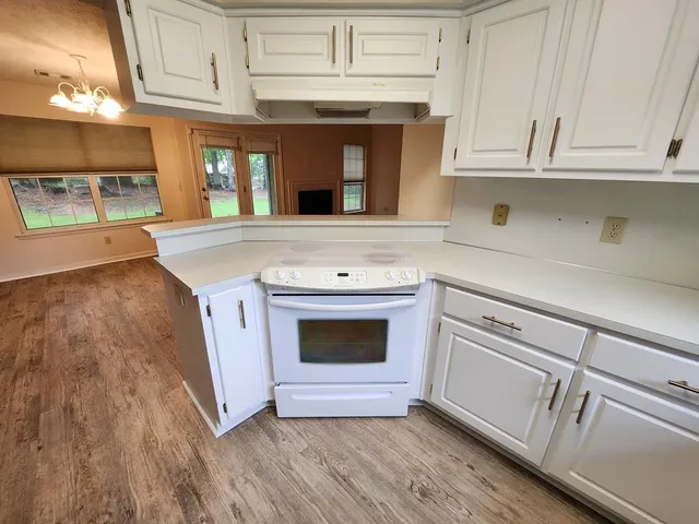 a kitchen with granite countertop white cabinets and white appliances