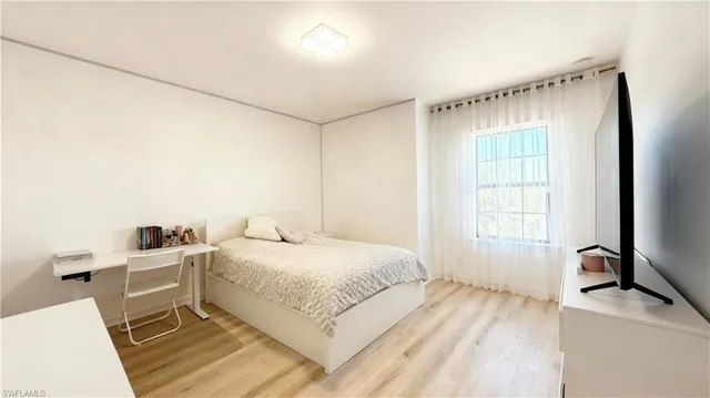 a bedroom with a bed and a large window