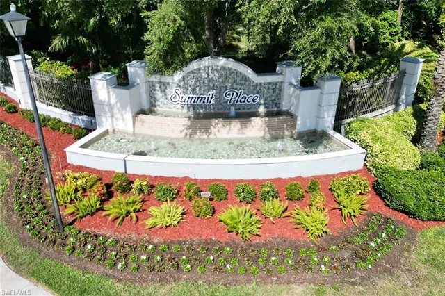 a view of a fountain with flower in front of house