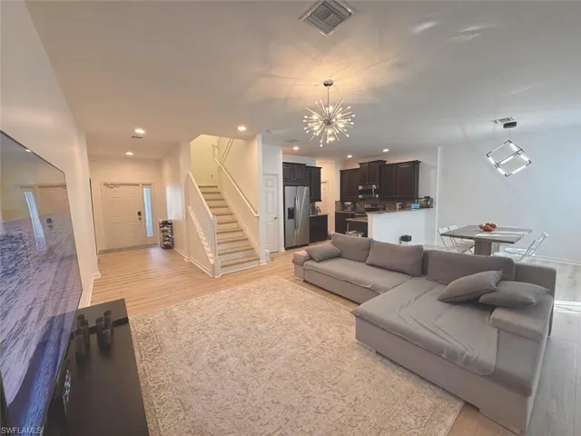 a living room with furniture and a chandelier