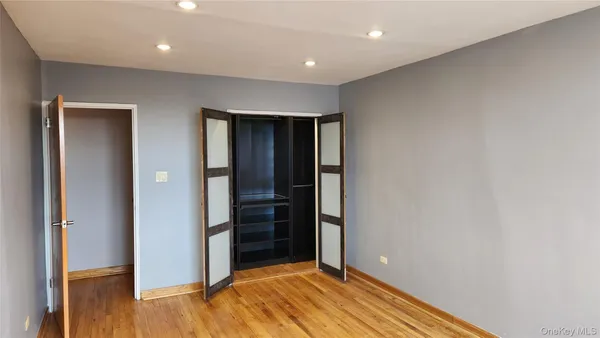 an empty room with closet and wooden floor