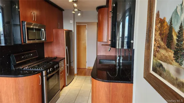 a kitchen with stainless steel appliances granite countertop a refrigerator and a stove