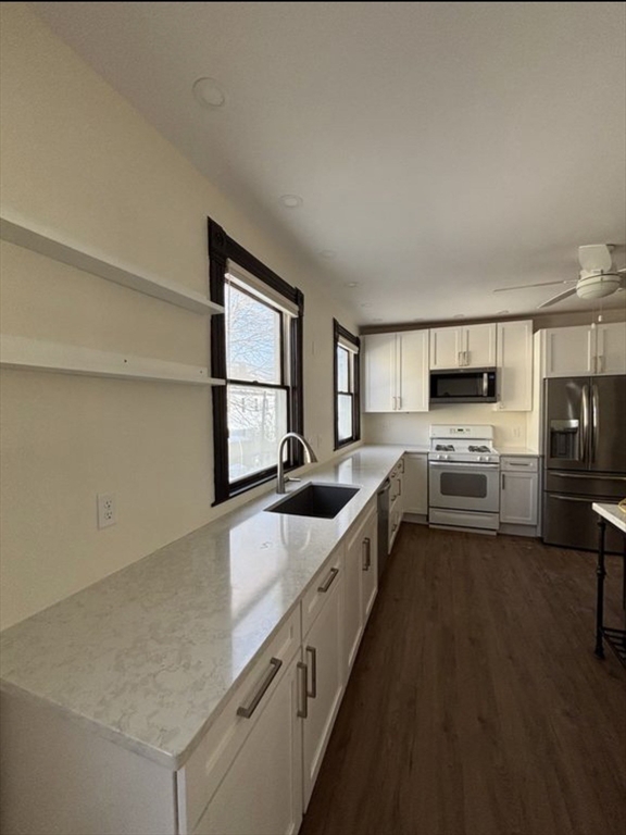 a large white kitchen with a stove a sink and a refrigerator