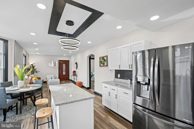 a kitchen with stainless steel appliances kitchen island granite countertop a refrigerator and microwave