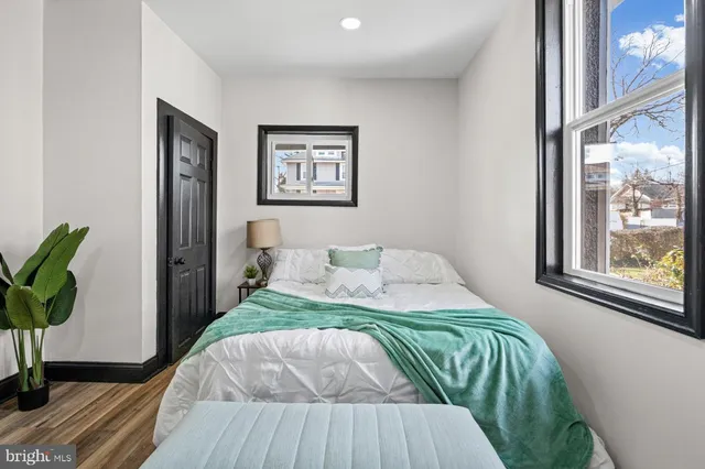 a bedroom with bed and wooden floor