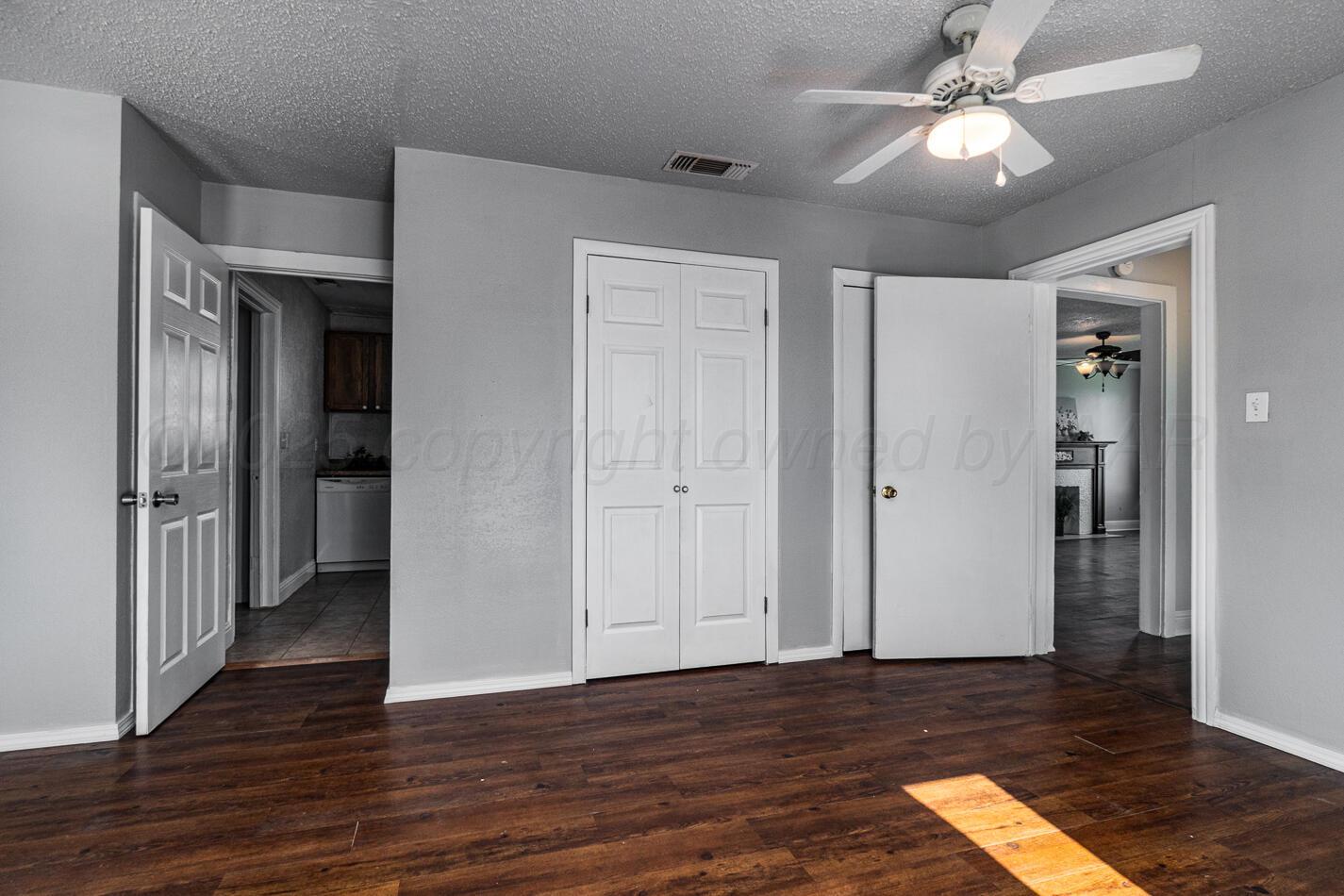 8015 Upton Road Amarillo, TX 79119 - Photo 10 of 16 a view of an empty room with wooden floor and a ceiling fan