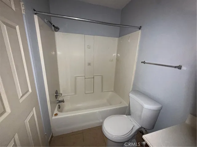 a white toilet sitting next to a bath tub and a shower