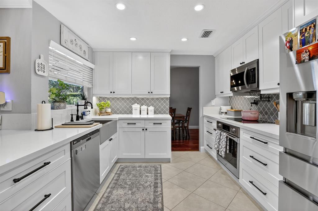 11611 Southwest 52nd Street Cooper City, FL 33330 - Photo 14 of 45 a kitchen with a sink stove and microwave