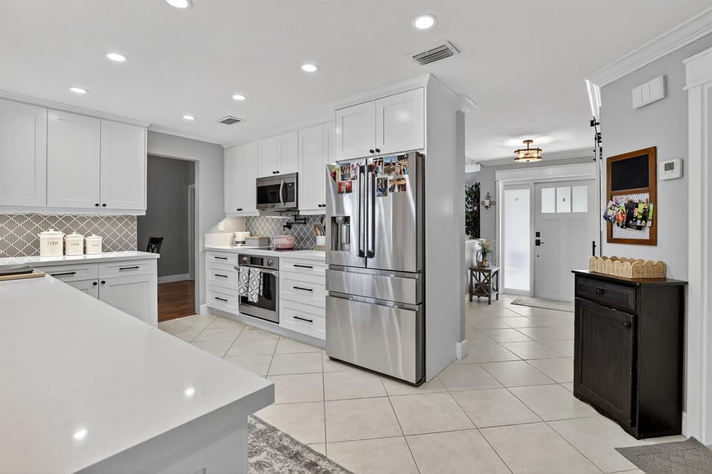 11611 Southwest 52nd Street Cooper City, FL 33330 - Photo 15 of 45 a kitchen with stainless steel appliances kitchen island granite countertop a refrigerator and a stove top oven