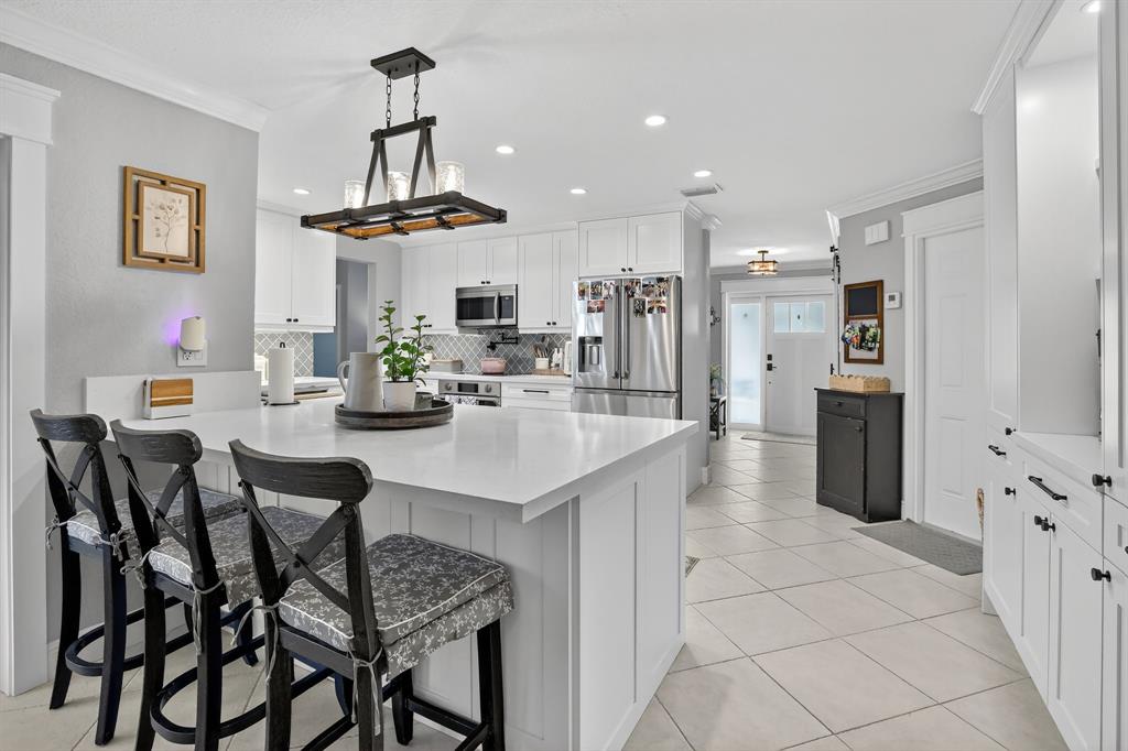 11611 Southwest 52nd Street Cooper City, FL 33330 - Photo 16 of 45 a kitchen with stainless steel appliances kitchen island granite countertop a table chairs and a refrigerator