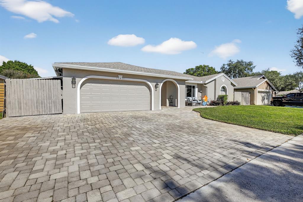 11611 Southwest 52nd Street Cooper City, FL 33330 - Photo 2 of 45 a front view of a house with a yard and garage
