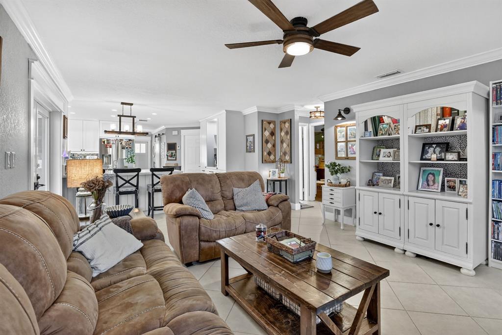 11611 Southwest 52nd Street Cooper City, FL 33330 - Photo 21 of 45 a living room with furniture a ceiling fan and a book shelf