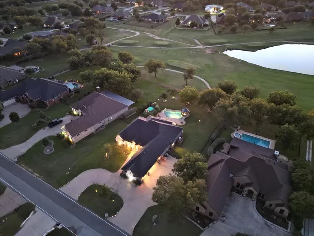 an aerial view of a house with a yard and swimming pool