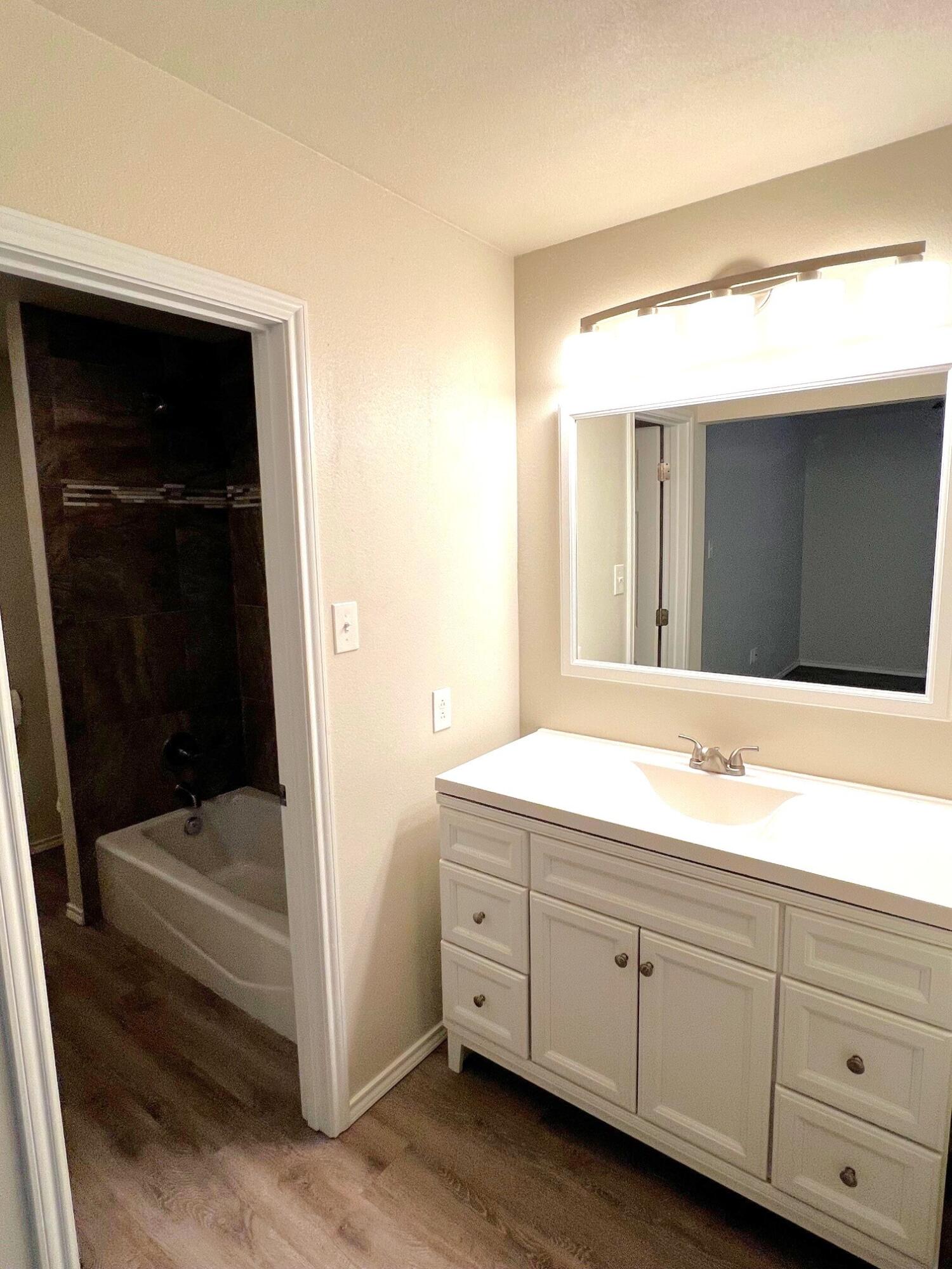7504 Avenue West, Unit A Lubbock, TX 79423 - Photo 11 of 17 a bathroom with a tub shower and sink