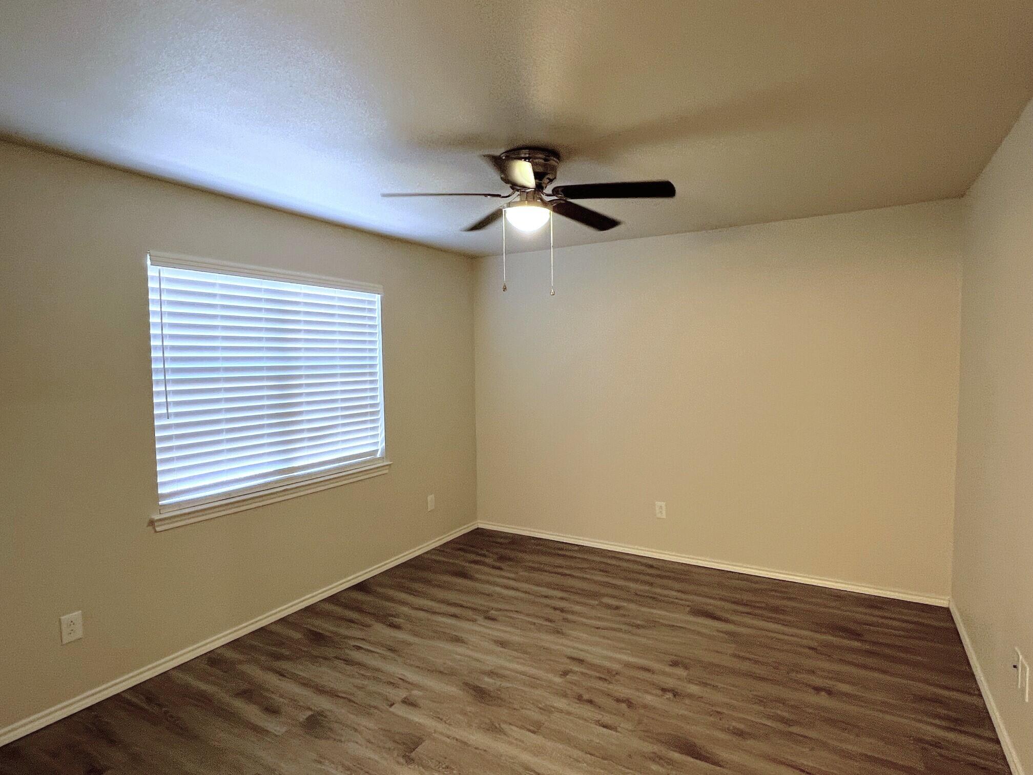 7504 Avenue West, Unit A Lubbock, TX 79423 - Photo 12 of 17 a view of empty room with wooden floor and fan