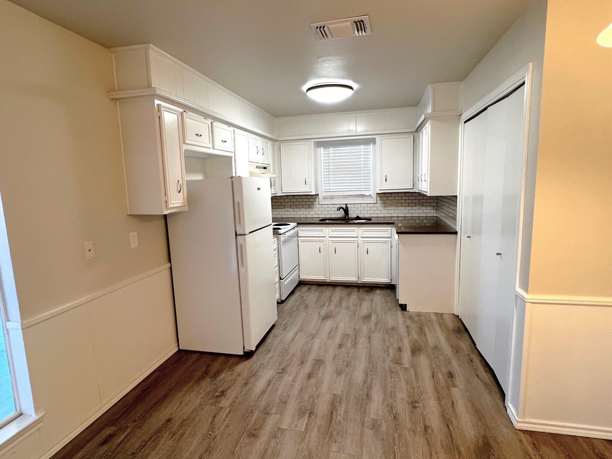 7504 Avenue West, Unit A Lubbock, TX 79423 - Photo 4 of 17 a kitchen with white cabinets and white appliances