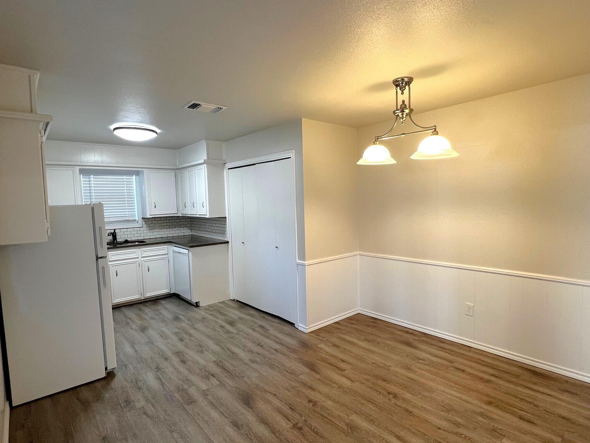 7504 Avenue West, Unit A Lubbock, TX 79423 - Photo 5 of 17 a kitchen with a refrigerator and white cabinets