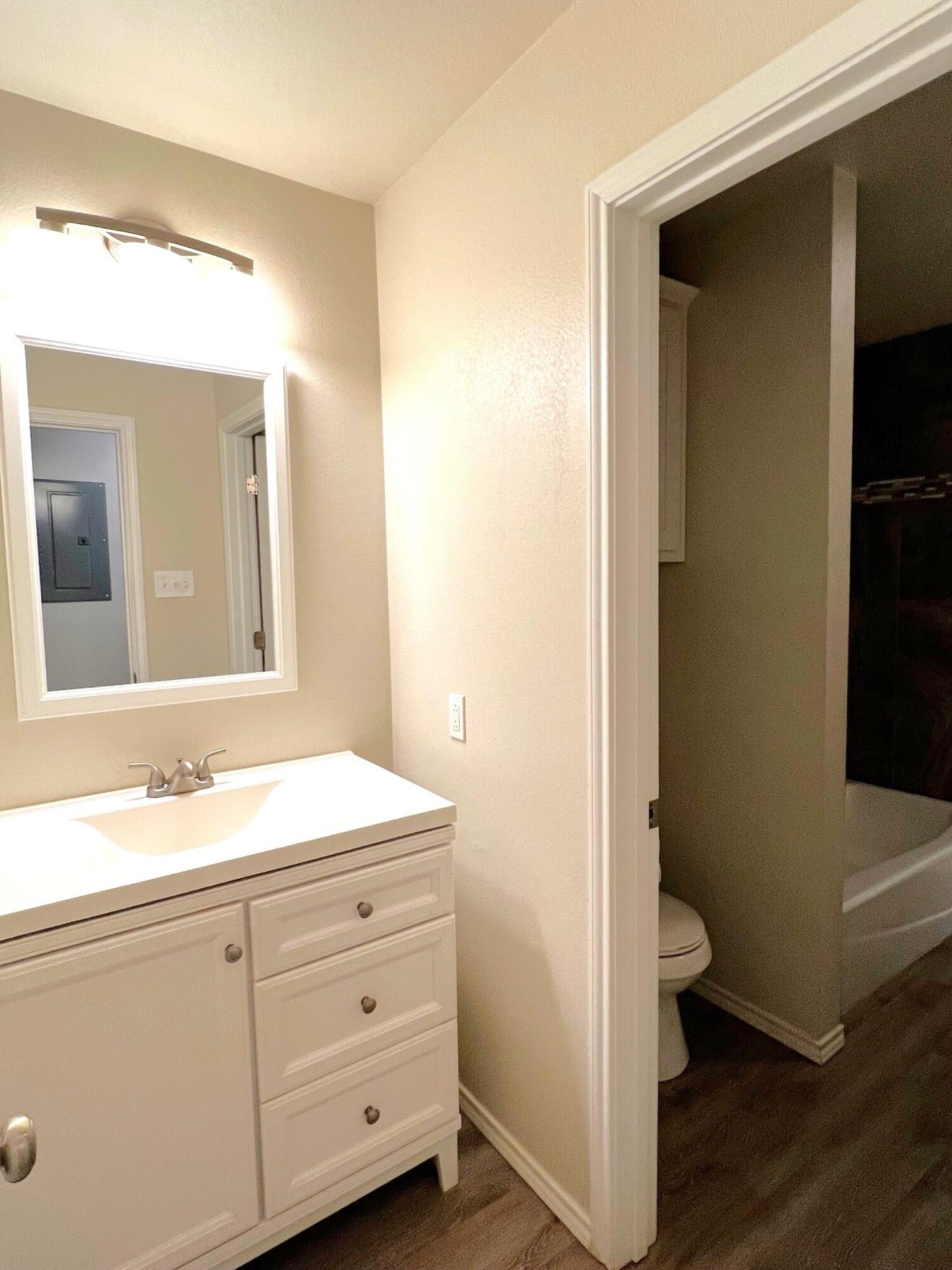 7504 Avenue West, Unit A Lubbock, TX 79423 - Photo 9 of 17 a bathroom with a sink a toilet and a mirror