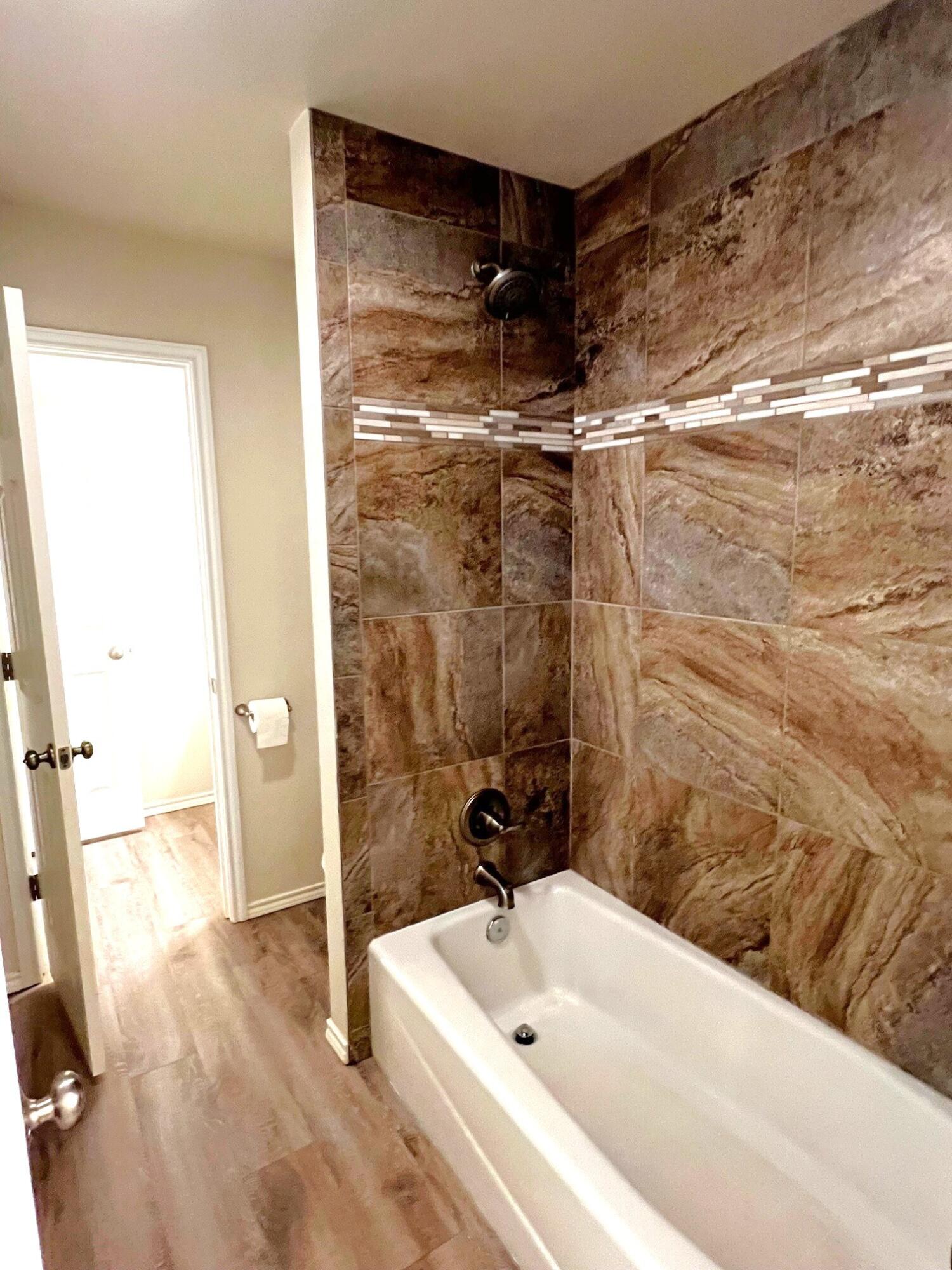 7504 Avenue West, Unit A Lubbock, TX 79423 - Photo 10 of 17 a bathroom with a tub and a shower