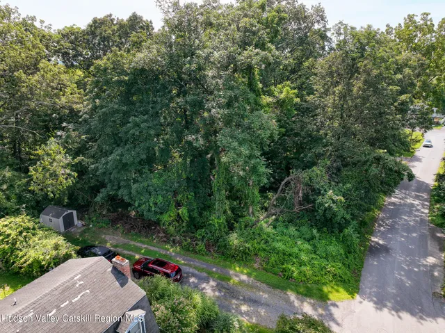 an aerial view of residential house with outdoor space and trees all around
