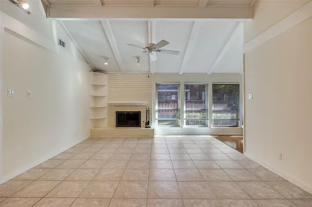 a view of an empty room with a fireplace and a window