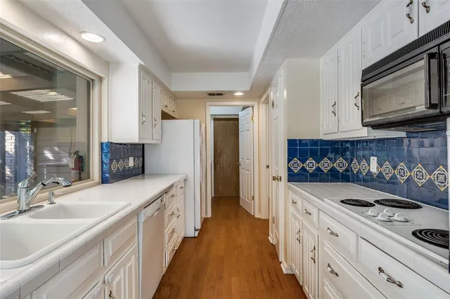 a kitchen with stainless steel appliances a stove a sink and a microwave