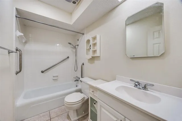 a bathroom with a granite countertop sink a toilet and bathtub